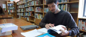 A man reads an open book in a library