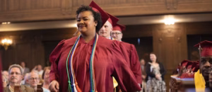 A row of Bidwell Training Center graduates walk down an isle