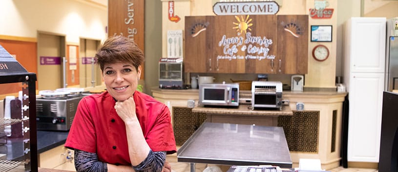 A Bidwell Training Center Alumna smiles, she is working in her business called 'Anna's Sunrise Cafe and Catering'.