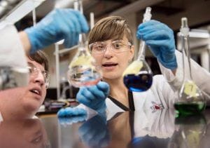 Two women in lab coats work in a chemistry laboratory 